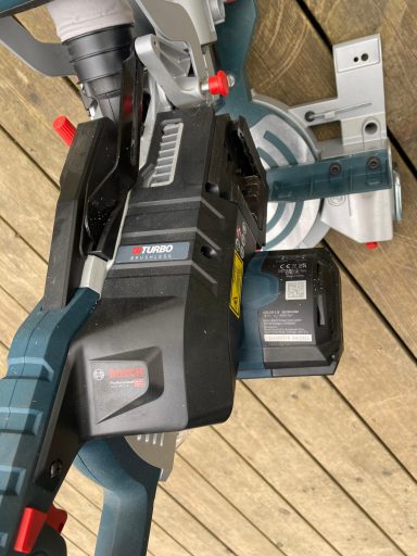 Eine Akku-Kapp- und Gehrungssäge mit Frontansicht auf dem Arbeitsbereich.